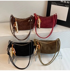 Assorted suede half-moon shoulder bags with ethnic tassel charms in four retro colors