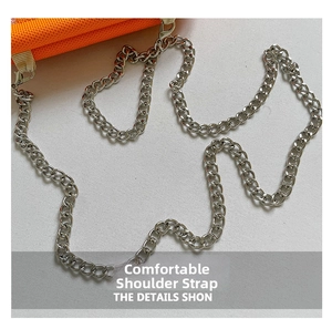Detalle de la correa de cadena de metal plateado en el bolso de tela naranja con eslabones