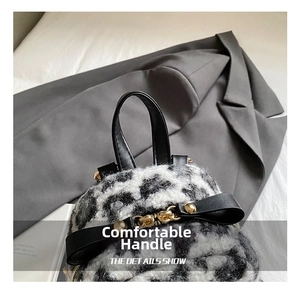 Close-up of leopard print faux fur backpack with black leather handle and gold hardware