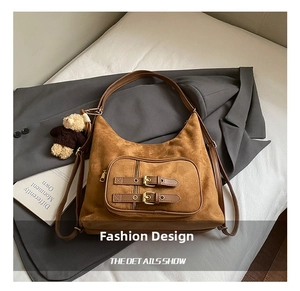 Dettaglio della borsa hobo in finta pelle scamosciata marrone con doppie fibbie e ciondolo orso