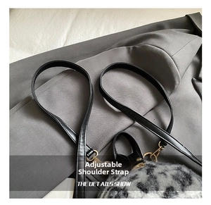 Detail showing plush leopard print texture and adjustable black leather strap with gold hook