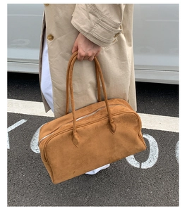 Detalle de un bolso Boston de ante marrón con cremallera para el estilo de diario
