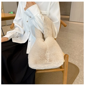 Close-up of soft beige plush faux fur handbag with fluffy texture and round handle