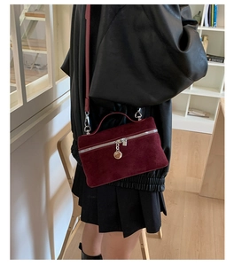 Detail of burgundy suede mini square bag with silver zipper and round ring pendant