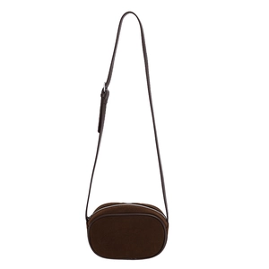 Minimalist brown matte suede crossbody bag with oval design and silver top zipper