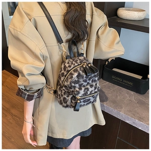 Detail view of mini leopard print plush backpack with black leather straps and gold zipper