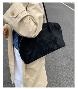 Primer plano del bolso Boston de ante negro con textura mate y diseño de gran capacidad