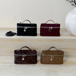 Detail of four matte suede mini handbags in black, burgundy, coffee, and camel colors