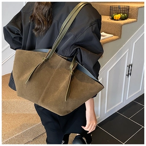 Detail of olive green suede tote bag featuring unique handcrafted knot shoulder straps