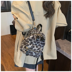 Close-up of leopard print plush mini backpack with gold zippers and black straps