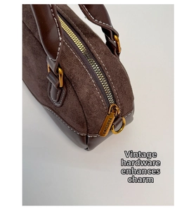 Detalle del bolso Boston vintage con patchwork de ante marrón y cremalleras doradas retro