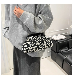 Detalle de un bolso nube con estampado de leopardo y cadena plateada en una modelo