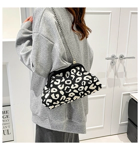 Detalle del bolso de punto con cadena, estampado de leopardo en blanco y negro y plata