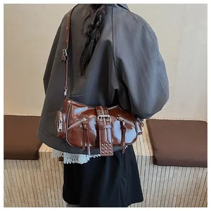 Detail of vintage dark brown Y2K shoulder bag with silver zippers and buckle straps