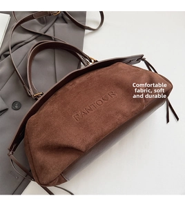Detail of brown suede and smooth leather bag with embossed PANTOUR logo on the front