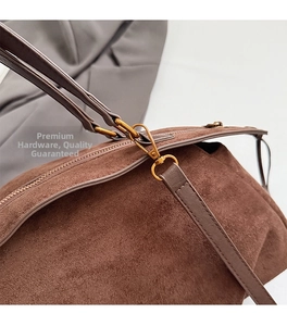 Detailed close-up of premium gold hardware and brown suede texture on a vintage bag