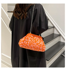 Détail du sac bandoulière en tricot léopard avec chaîne argentée porté au dos