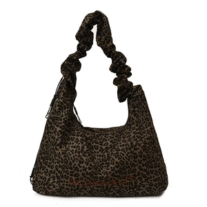Detail of leopard print tote bag featuring ruffled handles and DCERIVALIS logo