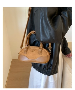 Detalle del bolso Boston marrón con logo Pan Tor llevado por modelo con chaqueta de cuero negra