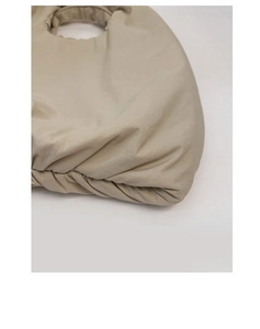 Dettaglio della borsa in nylon beige con design a pieghe e manico superiore integrato