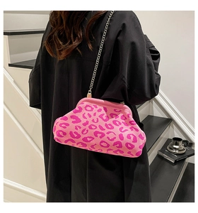 Detalle de bolso de punto leopardo rosa con cadena dorada en el hombro del modelo