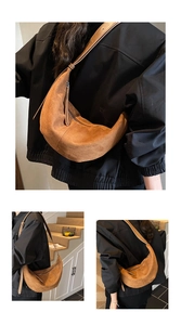 Detailed close-up of brown suede crescent bag with smooth zipper and adjustable strap