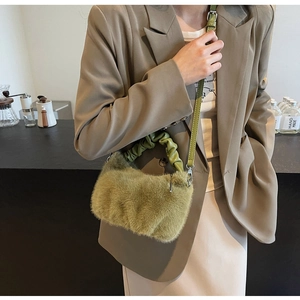 Détail d'un sac bandoulière en fausse fourrure vert olive à texture plissée