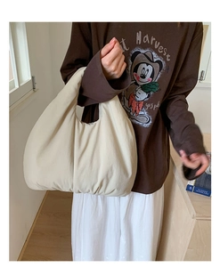 Detailed close-up of large cream dumpling tote bag showing soft matte fabric and puff texture