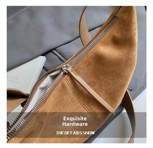 Close-up of premium silver metal zipper and fine stitching on a brown suede hobo bag