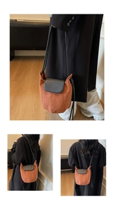 Détail d'un sac seau chic rouge brique avec rabat en cuir noir et fine bandoulière
