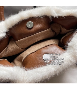 Close-up of magnetic silver clasp on brown leather handbag with white plush fur trim