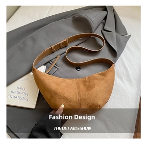 Macro view of a brown suede crescent bag texture on a grey blazer for classic style