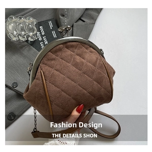 Detail of vintage brown quilted suede handbag with kiss-lock closure and chain strap