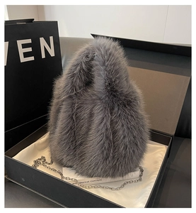 Détail macro d'un sac à main en fausse fourrure grise avec chaîne métallique en coffret cadeau