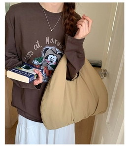 Grande borsa a mezzaluna in nylon kaki abbinata a una felpa marrone in stile casual