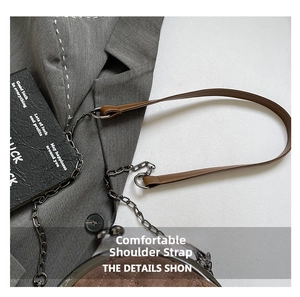 Detail of a brown quilted shell bag featuring a comfortable metal chain and leather strap