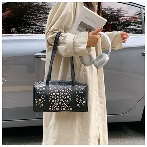 Detailed view of black cylindrical Boston bag featuring all-over silver stud embellishments