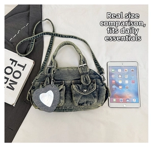 Detail of vintage denim crossbody bag featuring utility pockets and heart mirror charm
