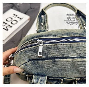 Close-up of smooth silver zipper and washed denim texture on vintage bowling bag