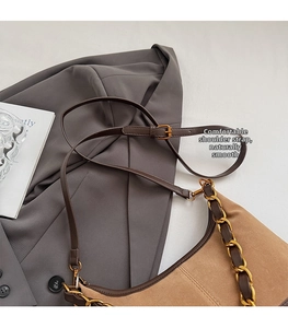 Detail der braunen Wildledertasche mit Goldkette und verstellbarem Lederriemen