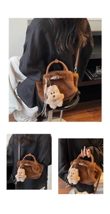 Detail of plush brown bucket bag with leather handles and cute teddy bear charm accessory