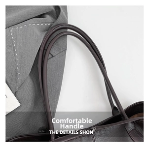 Vista macro di una borsa tote in pelle marrone scuro con manico arrotondato liscio