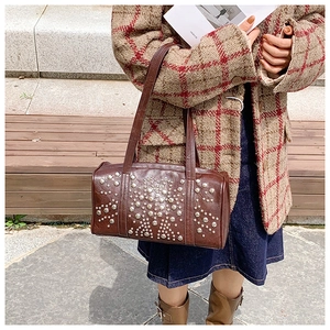 Close-up of retro dark brown Boston bag featuring decorative silver metal studs details