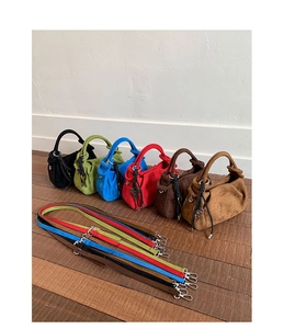 Detailed view of colorful pleated suede crossbody bags with heart charms and woven drawstrings