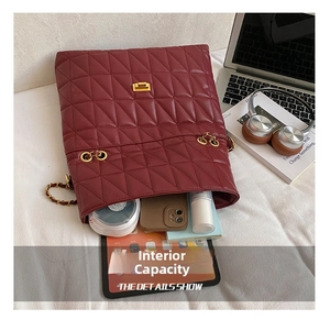 Macro detail of wine red quilted bag interior showing capacity for tablet and phone