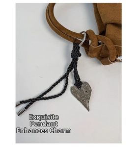 Detail of silver hammered heart charm with black braided rope on suede bucket bag