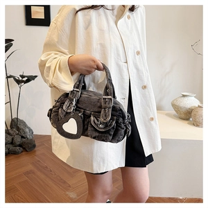 Detail of vintage washed black denim handbag with silver studs and heart mirror charm