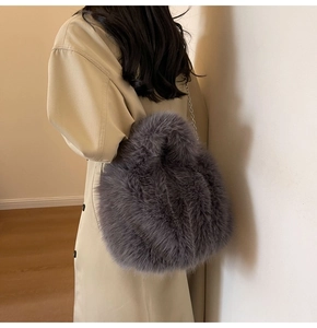 Détail d'un sac à main en fausse fourrure grise avec bandoulière chaîne en métal
