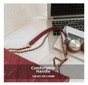 Close-up of wine red quilted leather shoulder bag with classic metal chain strap