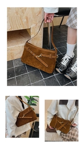 Detail of vintage brown suede tote bag featuring decorative straps and gold hardware accents